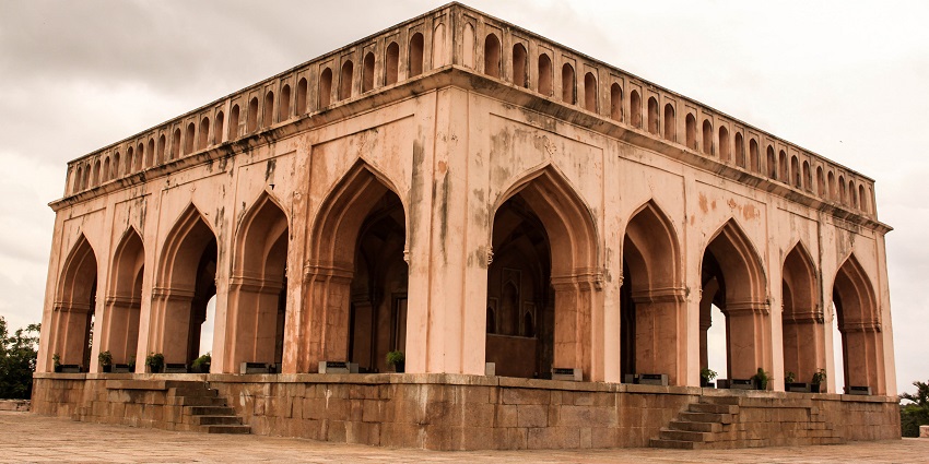 Historic Taramati Baradari features twelve arched openings against a clear blue sky.