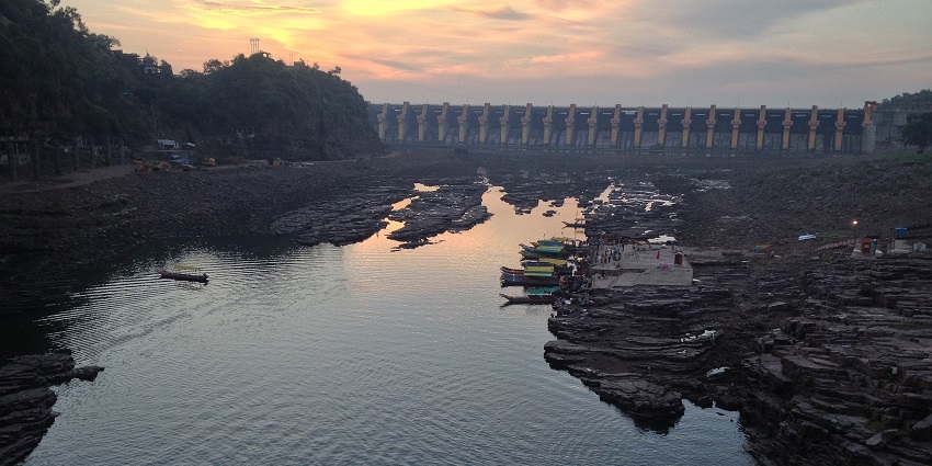 Tawa Reservoir and Dam with calm water and sunset in the sky.