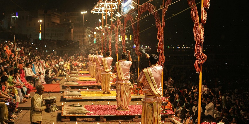 Evening view of Ganga Aarti at Varanasi with glowing lamps and peaceful river ambiance.