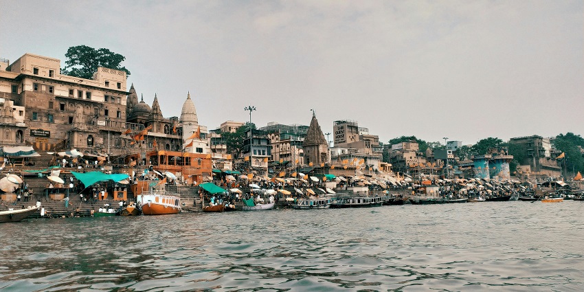 Historic waterfront buildings along the Ganges River in Varanasi showcase traditional architecture by the riverbank.