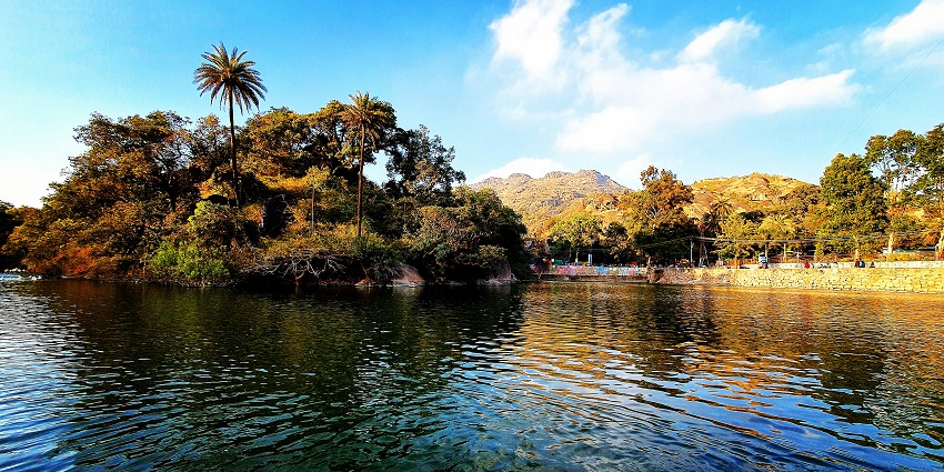 Mount Abu with distant hills, a lake, and lush greenery in the background.