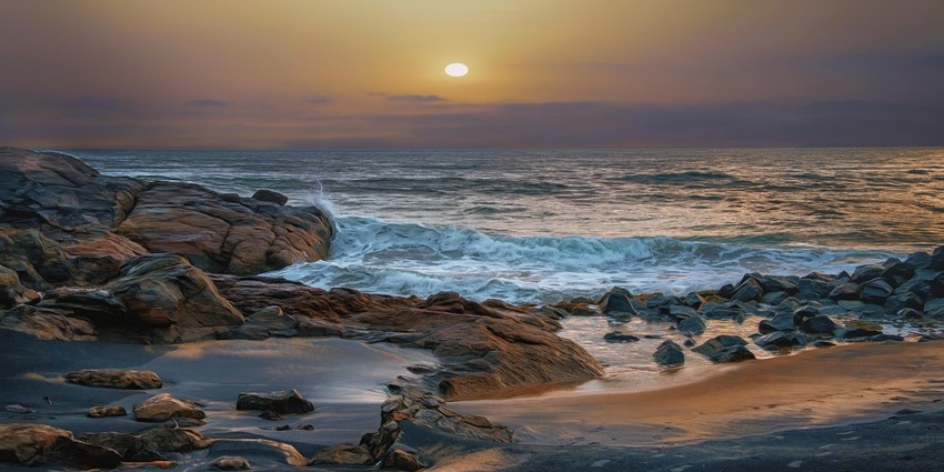Varkala beach with cliffside walkway and wide shore at sunset, one of the top places to visit near Attingal.
