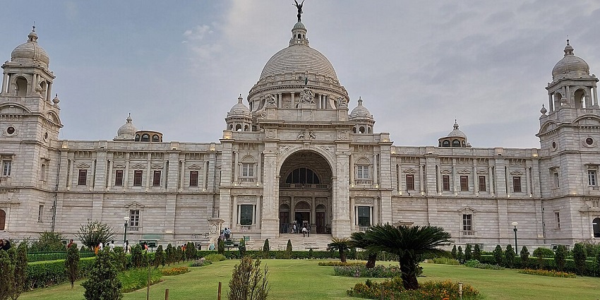 Victoria Memorial Hall with its grand architecture surrounded by gardens under a clear sky.

