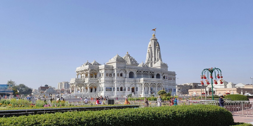 The grand structure of the Prem Mandir, built of marble, and people roaming in the complex, among the scenic places to visit near Govardhan.
