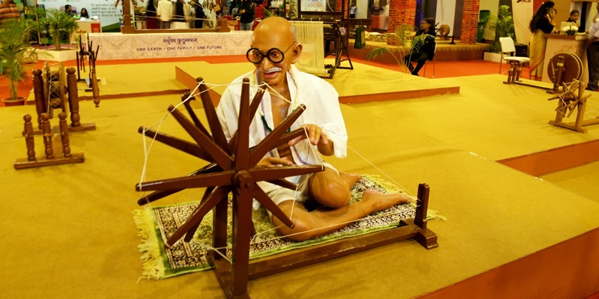 A view of Khadi India stall showing Mahatma Gandhi's statue at the spinning wheel.