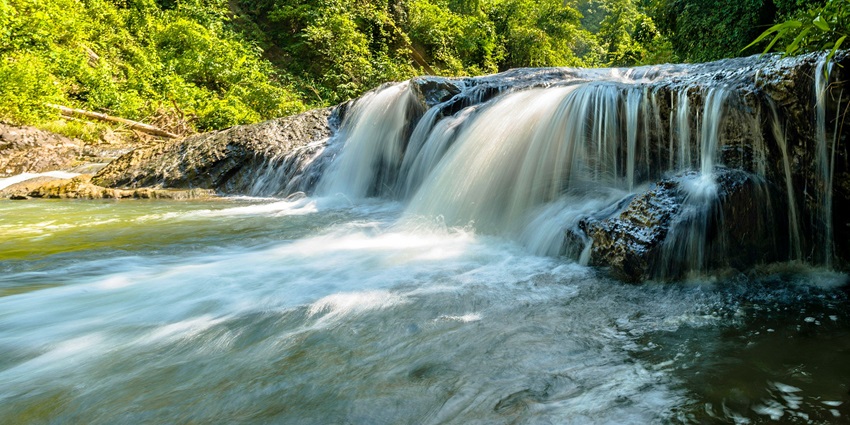 Alewa Waterfall cascading down rocky cliffs surrounded by forest in waterfalls in Rajasthan.
