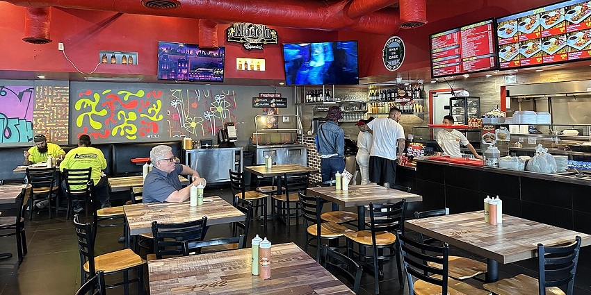 A busy fast-casual restaurant with many tables and customers in one of the vegetarian restaurants in Singapore Little India.
