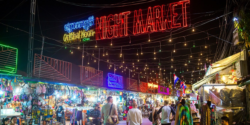 Evening view of Angkor Night Market with shoppers browsing local stalls and crafts.

