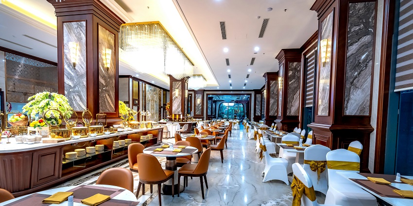 Luxurious dining hall with marble floors, golden accents, and neatly arranged tables among the multiple restaurants in Havelock Island.
