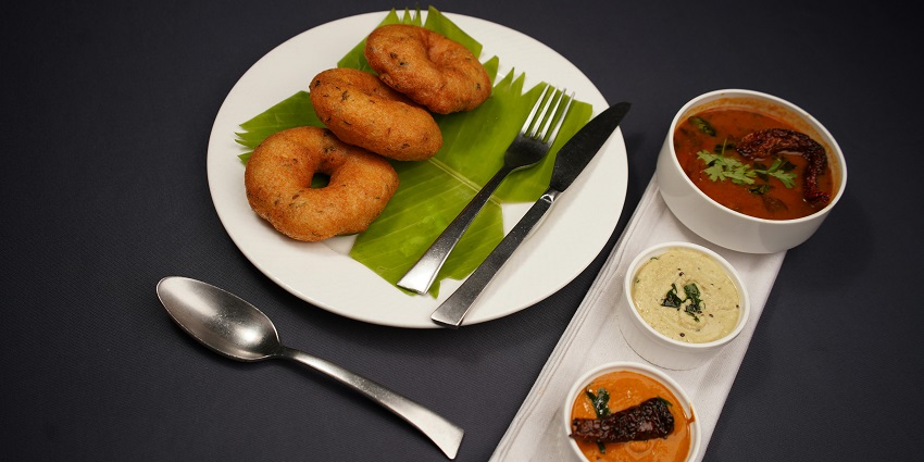 Sambar vada served with chutney at a vegetarian South Indian restaurant.