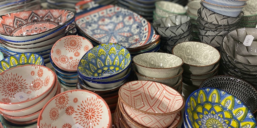 White, red, and green floral ceramic bowls are displayed at Apliu Street Flea Market.
