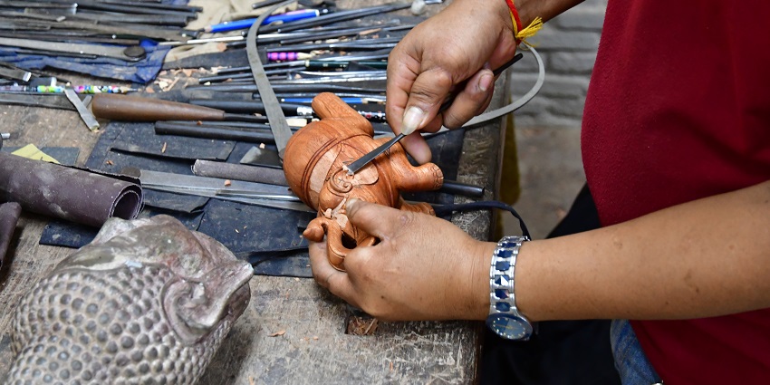 Craftsmen working on traditional Khmer art pieces at Artisans Angkor workshop.
