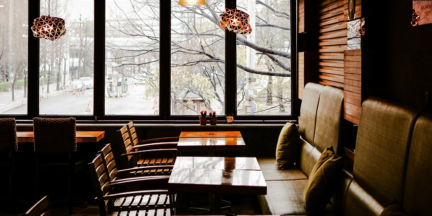Brown wooden table with matching chairs arranged neatly at Babesa Village Restaurant.
