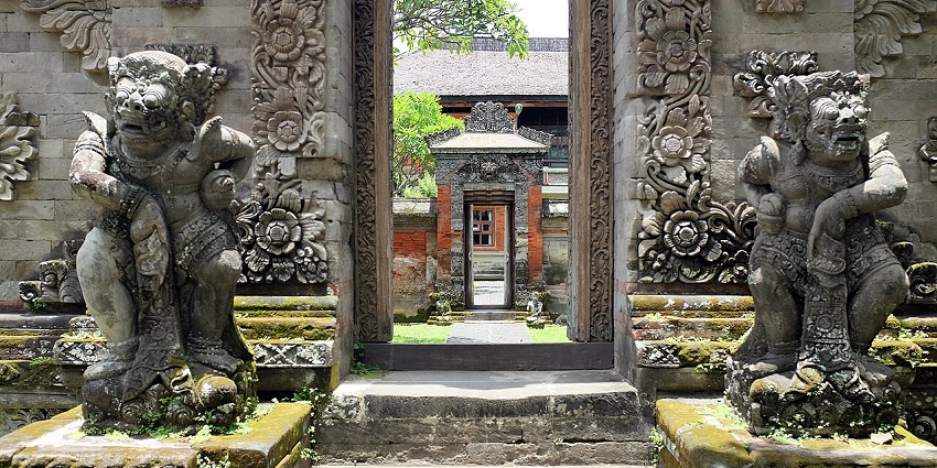Stone guardian statues flank a carved entrance at the Bali Museum, leading to the inner courtyard, one of the iconic museums in Bali.
