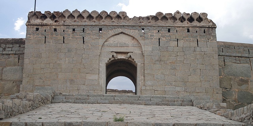 The stone gateway of Ballari Fort with an arched entrance and wide stone steps leading up, one of the top forts in Karnataka.