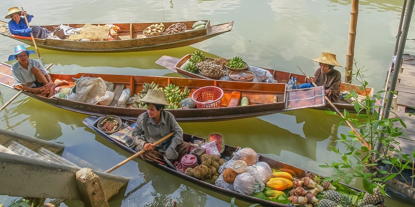 Traditional boats and vintage shops at Bang Noi floating market in Thailand.
