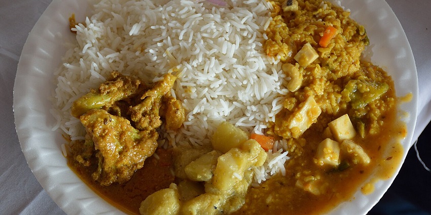 Plate filled with different dishes including Dal, vegetable, and paneer curry, and salads in one of the pure veg restaurants in Siliguri.