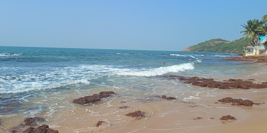 Rocky shoreline and clear waters at Bat Island beach in Goa.