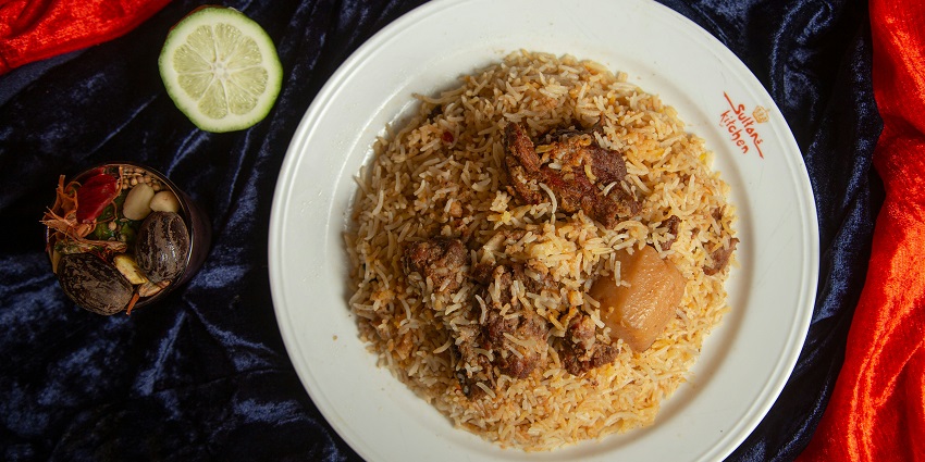 A large platter piled high with a generous serving of delicious, aromatic chicken biryani.
