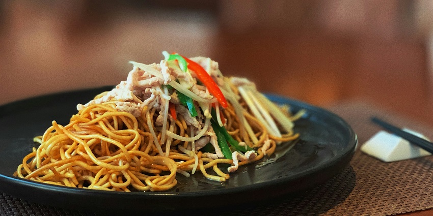 Noodles served at Beta KL, elegantly plated in a modern dining setting.