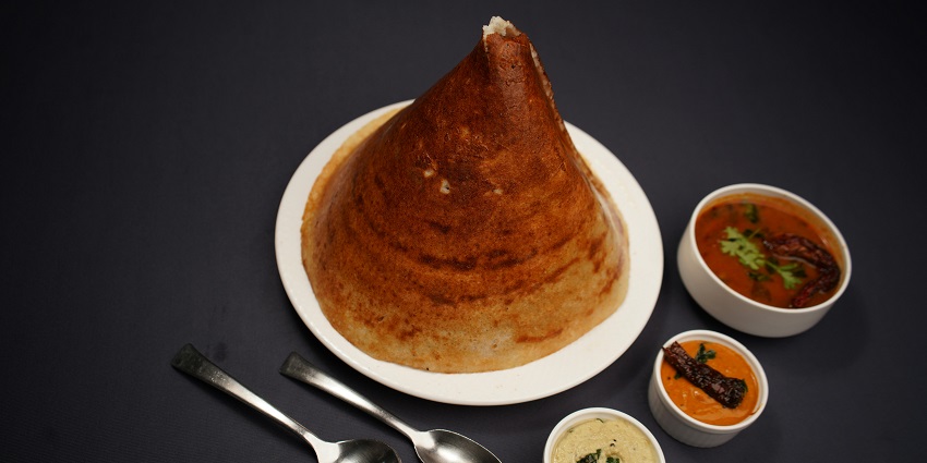 Dosa served with sambar and chutney at a South Indian restaurant.