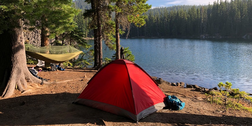 Camping tents at Bheemeshwari Adventure Camp with calm waters and greenery, camping in Karnataka.