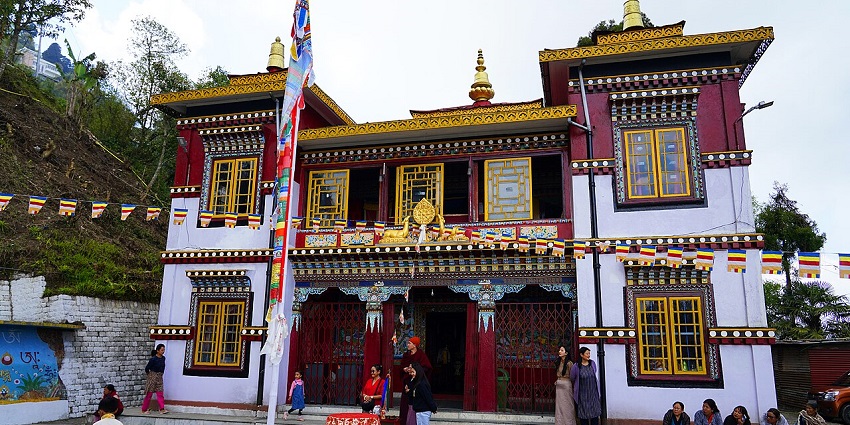 Exterior view of Bhutia Busti Monastery with traditional Tibetan architecture and colorful prayer flags.