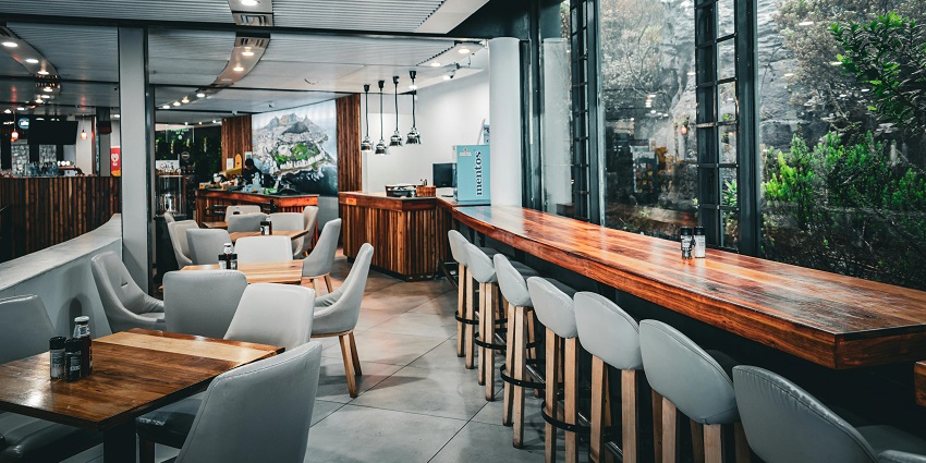 Modern café with wooden tables and glass windows at Big Bowl, a popular choice among restaurants in Pelling.
