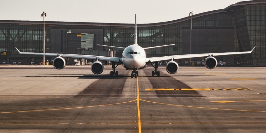 An airplane is ready to take off at Bir Tikendrajit International Airport on a clear runway day.