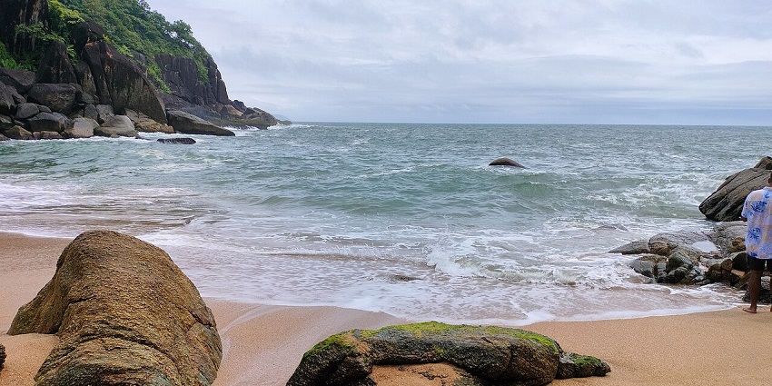 Butterfly beach in Goa with unique rocks on the sandy shoreline, clear water and low tides.
