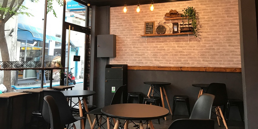 Cosy interior of Cafe Down Under with wooden tables, chairs, and warm lighted fixtures.