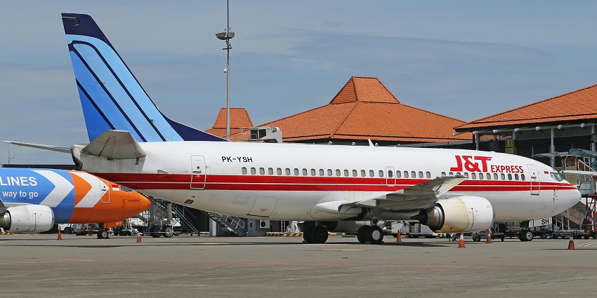 Airplane parked on the tarmac at Denpasar Airport during daytime.
