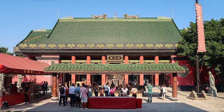 Che Kung Temple in Hong Kong with people visiting the temple and green roofs of the temple.