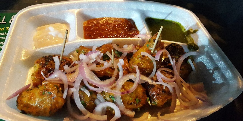 A plate of Indian street food snacks, likely kebabs, served with three dipping sauces in one of the restaurants in City Centre Siliguri.

