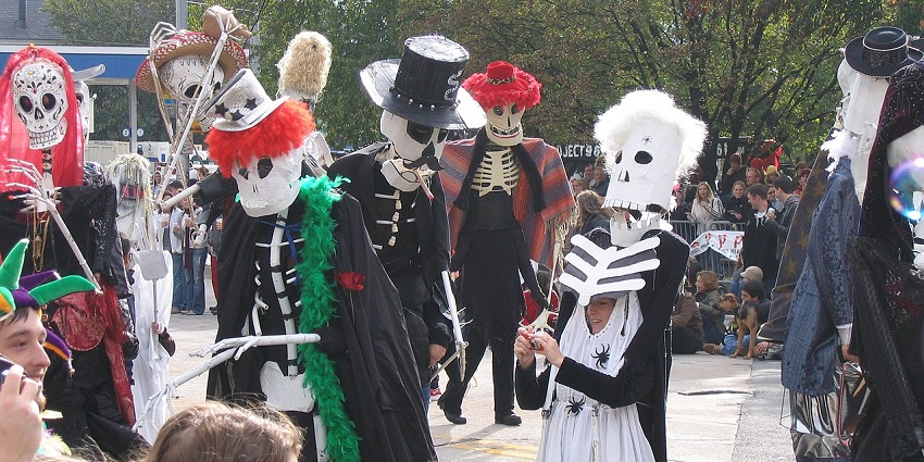 A group of people dressed in spooky costumes celebrate Halloween on the street, similar to what's expected in Halloween day 2025.