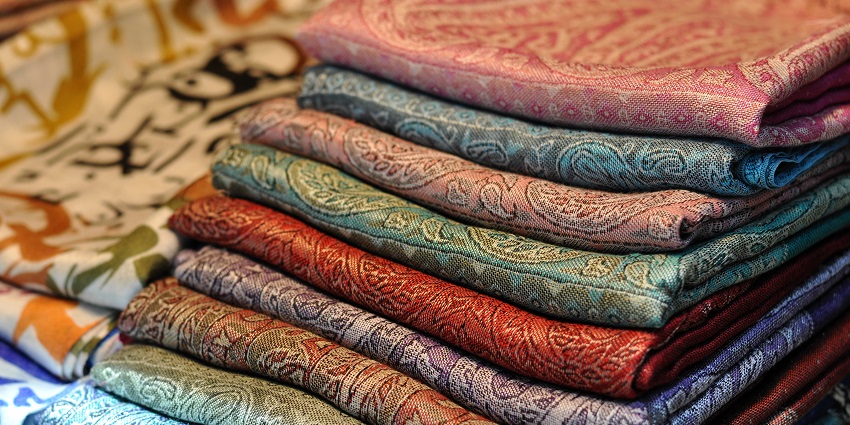 Stack of pashmina wool shawls displayed at Cottage Industries Emporium in Ladakh.
