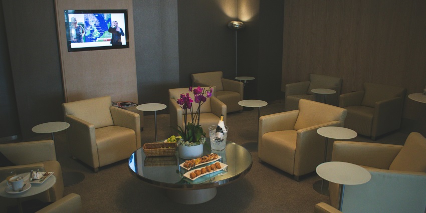 Spacious airport lounge with leather chairs and warm ambient lighting for travellers.
