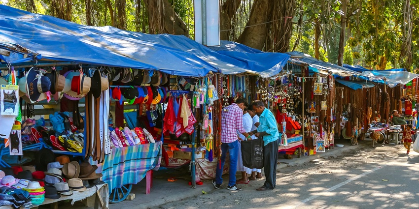 A bustling street market with colorful stalls selling souvenirs and festive items during Chhath celebrations..