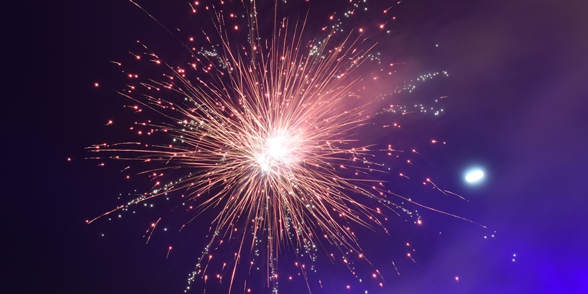 Fireworks captured in reverse, with sparkling trails appearing to move inward toward the sky.