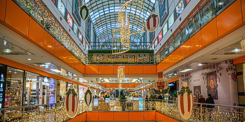 Spacious interior view of Forum Mall with multiple retail stores and shoppers browsing.
