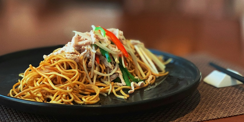 Noodles served on a black plate at Ginger Café, one of the top cafes in Port Blair.
