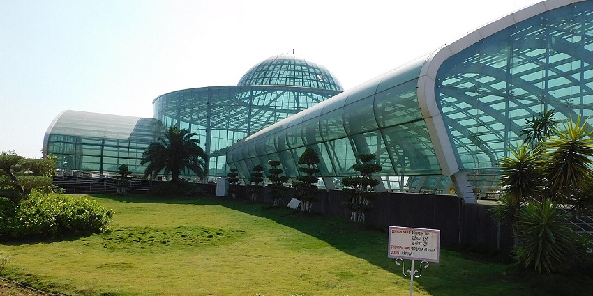 Glasshouse structure with lawns and plants at Glass House Garden in Davanagere.
