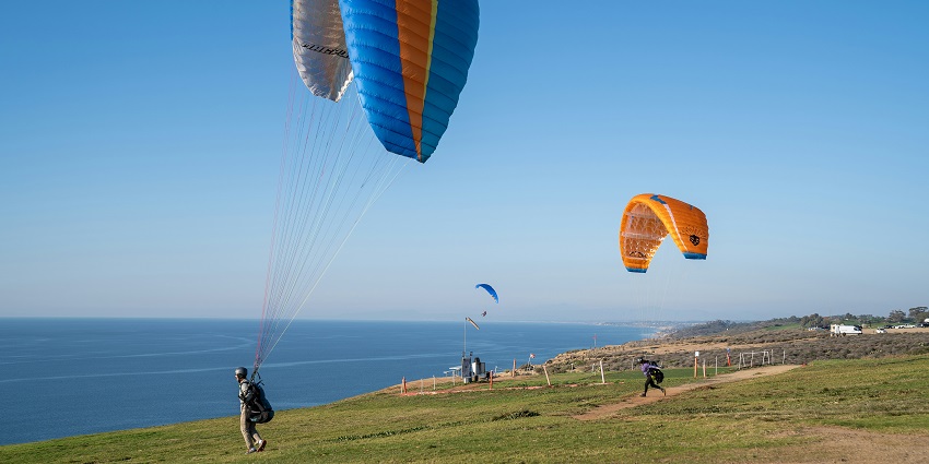 Paraglider ready to take off at Gokarna with scenic hills and coastal views in the background.
