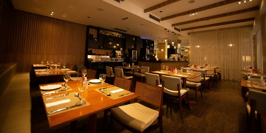 Cosy restaurant with wooden decor, soft lighting, and neatly arranged dining tables
