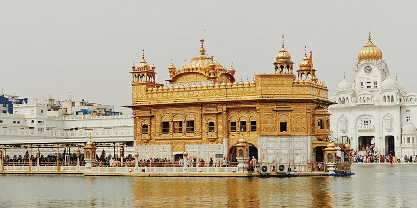 Golden Temple at daytime with calm water reflecting its beauty during Guru Nanak Jayanti 2025.