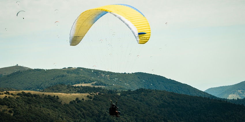 Paragliding over lush green forest at Hampi with scenic views and tranquil landscapes.