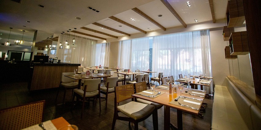 Spacious restaurant setup featuring wooden accents, glassware, and softly lit ambiance, one of the best restaurants in Clarke Quay.
