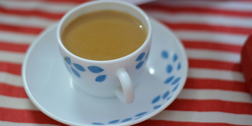 A cup of hot tea is served on a table at Hashtag Chai.