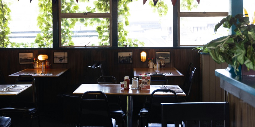A restaurant with many tables and chairs at Hasty Tasty in Darjeeling.
