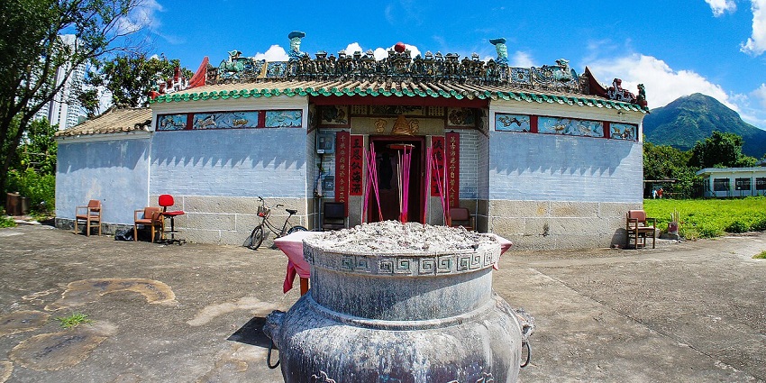 Hau Wong temple complex with a big incense burner pot in front of the temple building.
